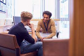 A student chats with their mentor in their office. 