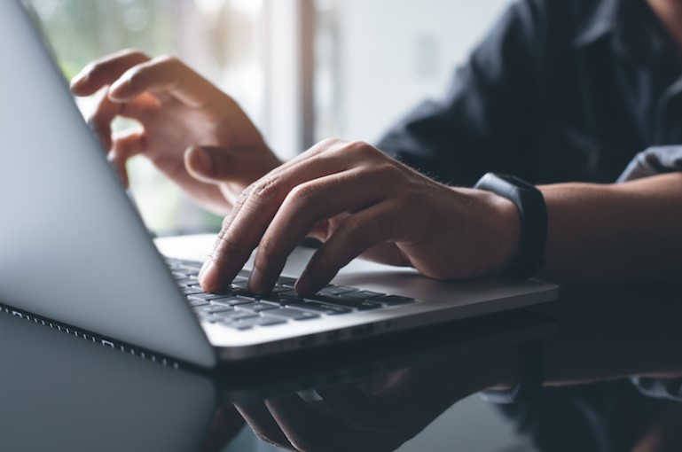 A close up on hands typing on a laptop.