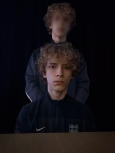 An AI generated image of a person with a blurred version of themselves standing behind and above them.